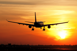 avião pousando pôr do sol