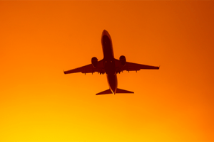 avião subindo céu laranja