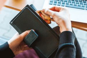 pessoa tirando cartao de credito da carteira