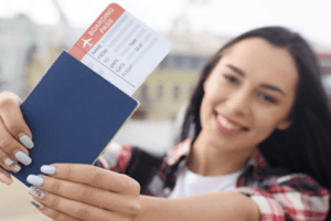 mulher feliz com passagem e passaporte