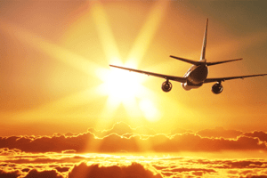 Avião voando sol ao fundo