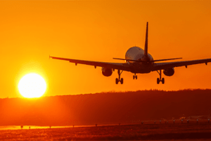 Avião decolando e sol se pondo