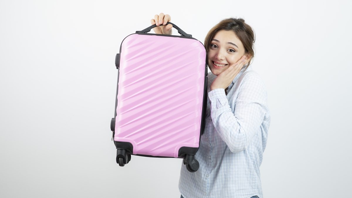 mulher segurando mala de viagem