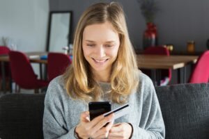 mulher com cartão e celular