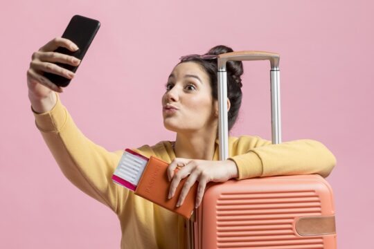 mulher tirando foto com mala de viagem