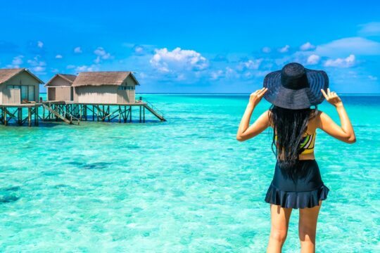 mulher em frente ao mar azul turquesa