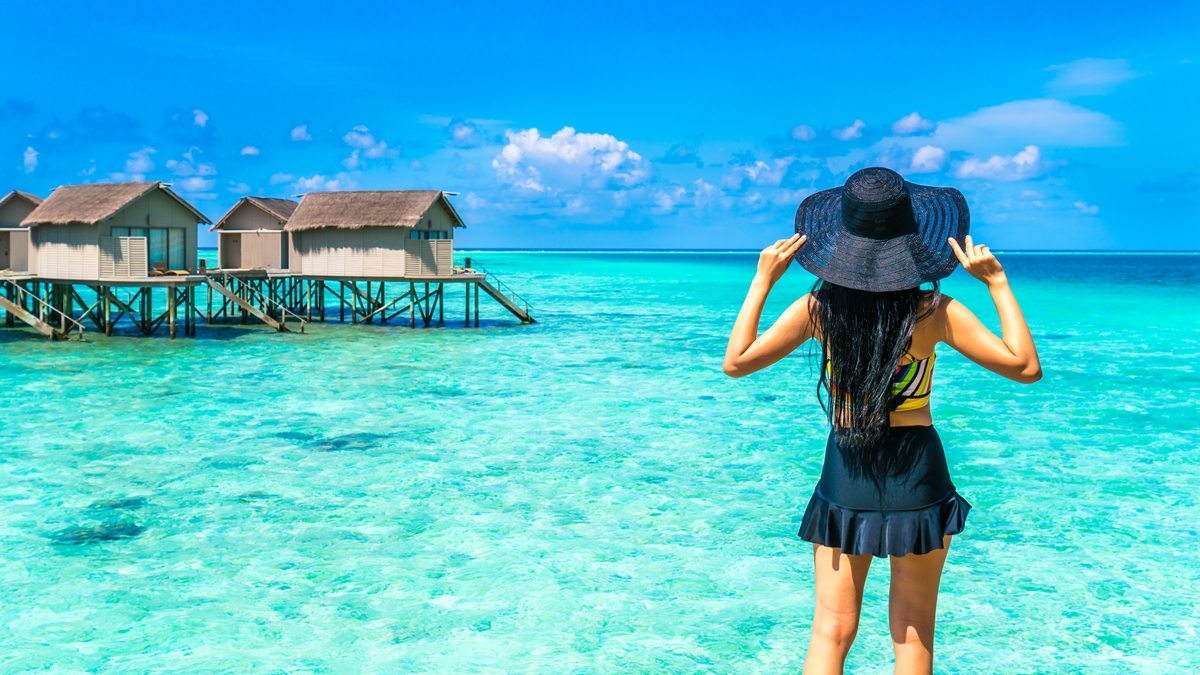 mulher em frente ao mar azul turquesa