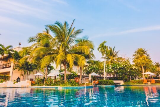 hotel com piscina e palmeiras