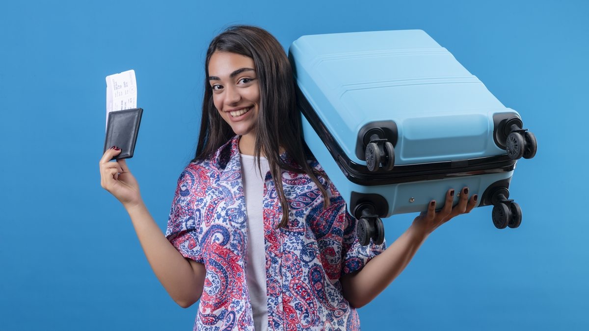 menina com mala e bilhete de viagem