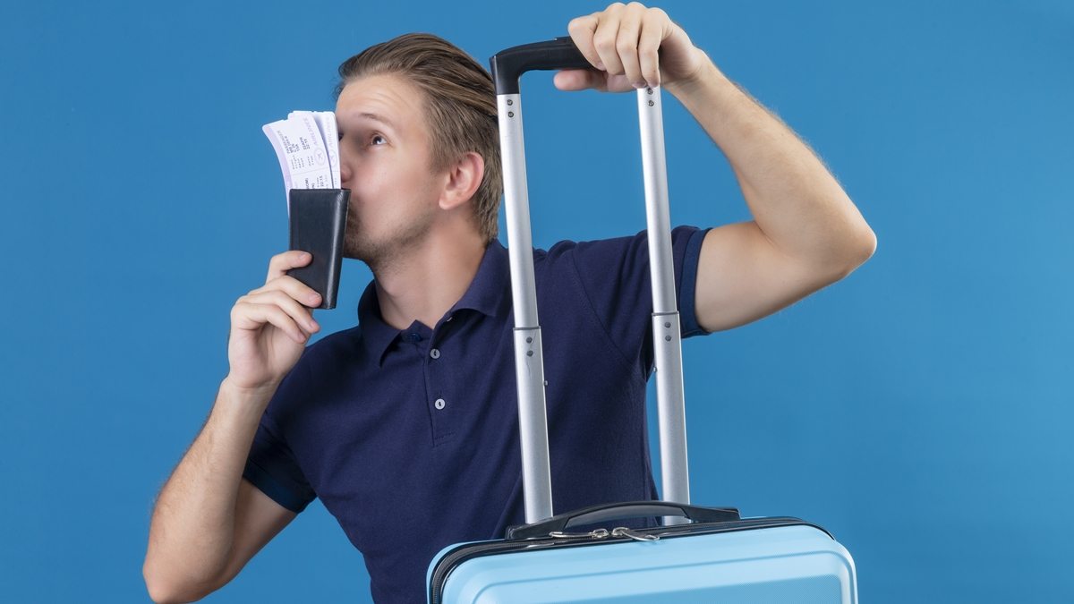 homem com mala e bilhetes de viagem
