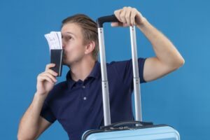 homem com mala de viagem e passagens