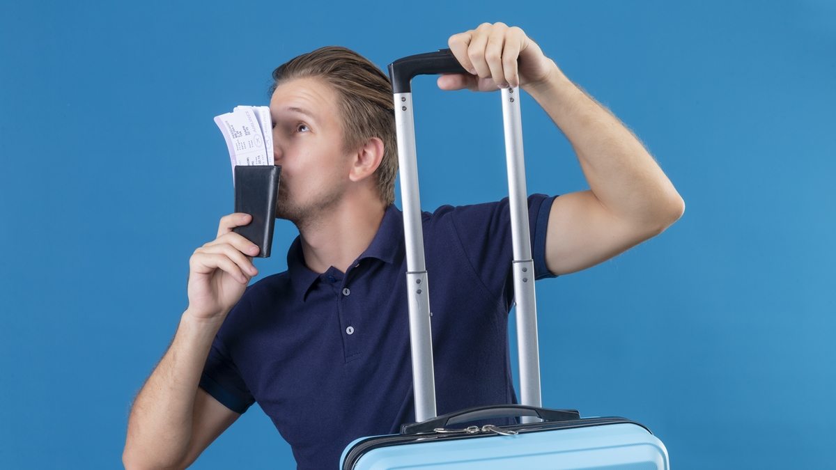 homem com mala de viagem e passagens