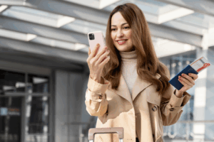 Mulher com celular e bilhetes aéreos na mão