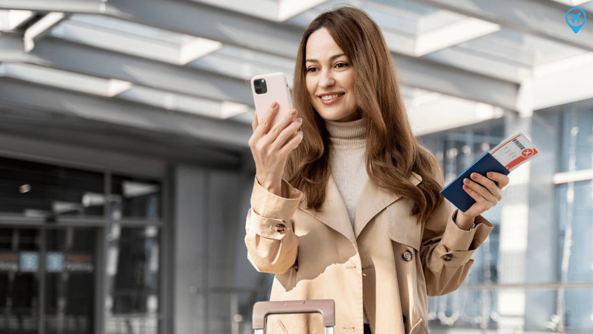 Mulher com celular e bilhetes aéreos na mão