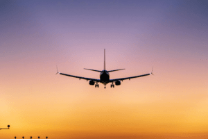 Avião comercial se aproximando para pouso ao entardecer.