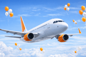Avião branco com detalhes em laranja em voo, simbolizando o Aniversário GOL 2026 e a promoção de 25 anos da companhia