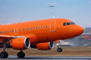 Avião pintando de laranja decolando