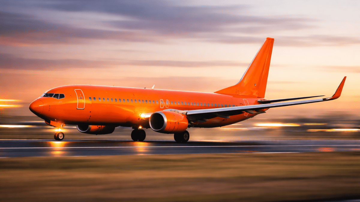 Avião laranja em velocidade na pista