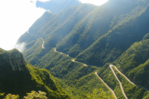 Vista aérea da Serra do Rio do Rastro, em Santa Catarina, com curvas sinuosas atravessando montanhas cobertas por vegetação