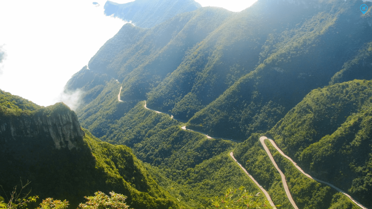 Vista aérea da Serra do Rio do Rastro, em Santa Catarina, com curvas sinuosas atravessando montanhas cobertas por vegetação