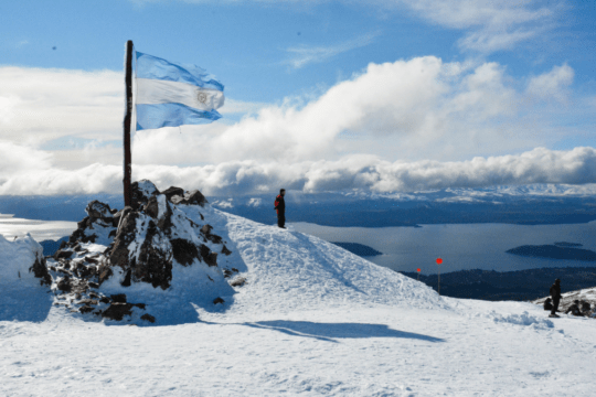 Montanha nevada com bandeira da Argentina em Bariloche