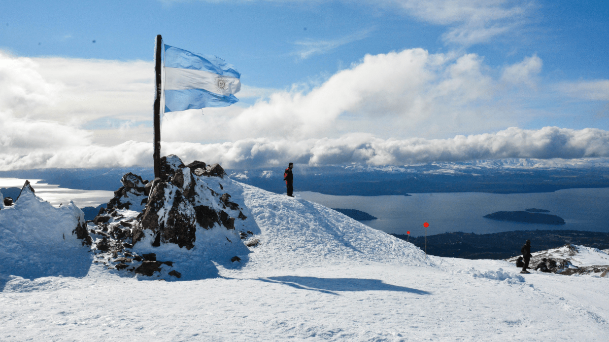Montanha nevada com bandeira da Argentina em Bariloche